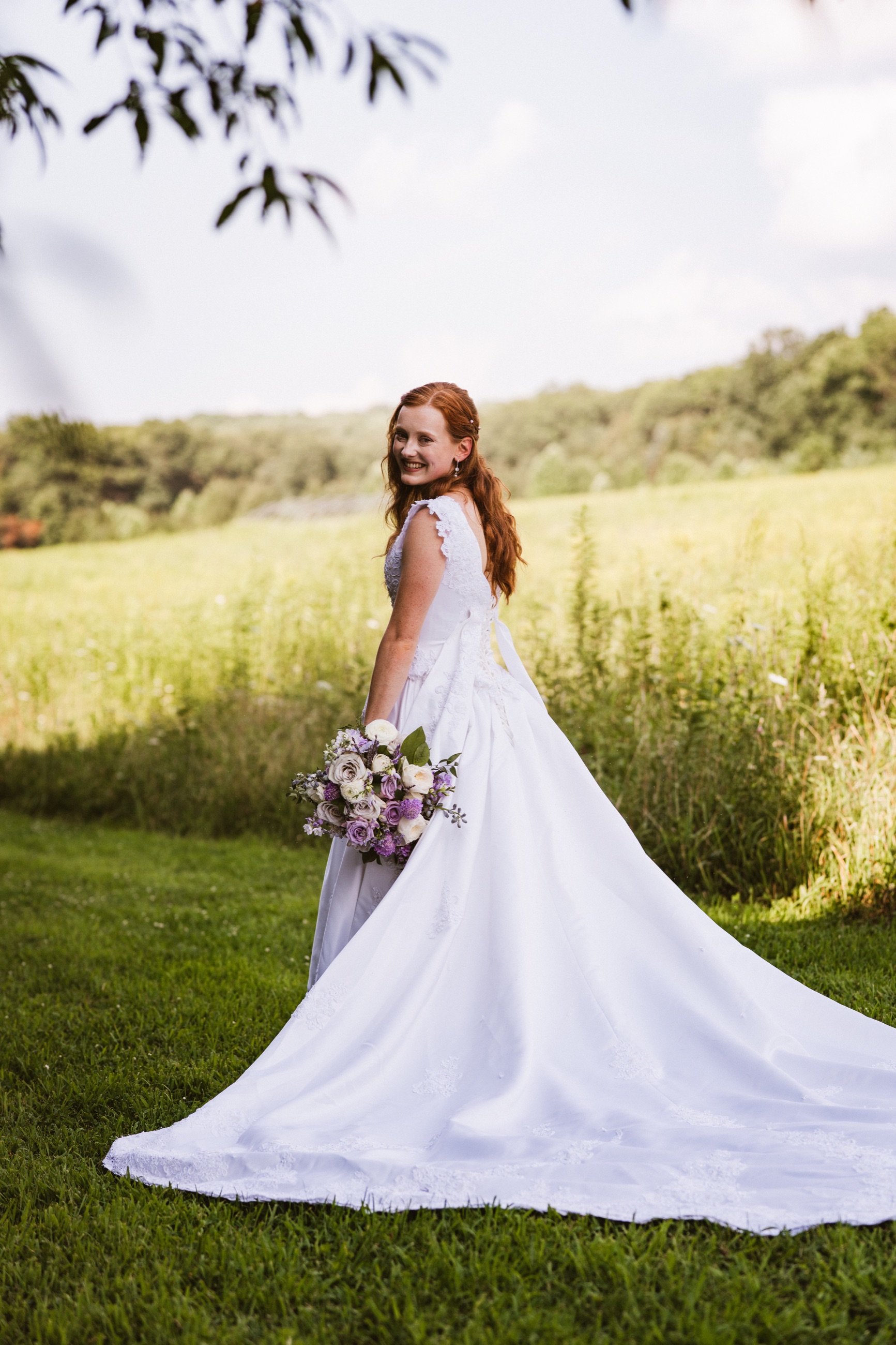 Bride holding a bouquet in a sunlit field