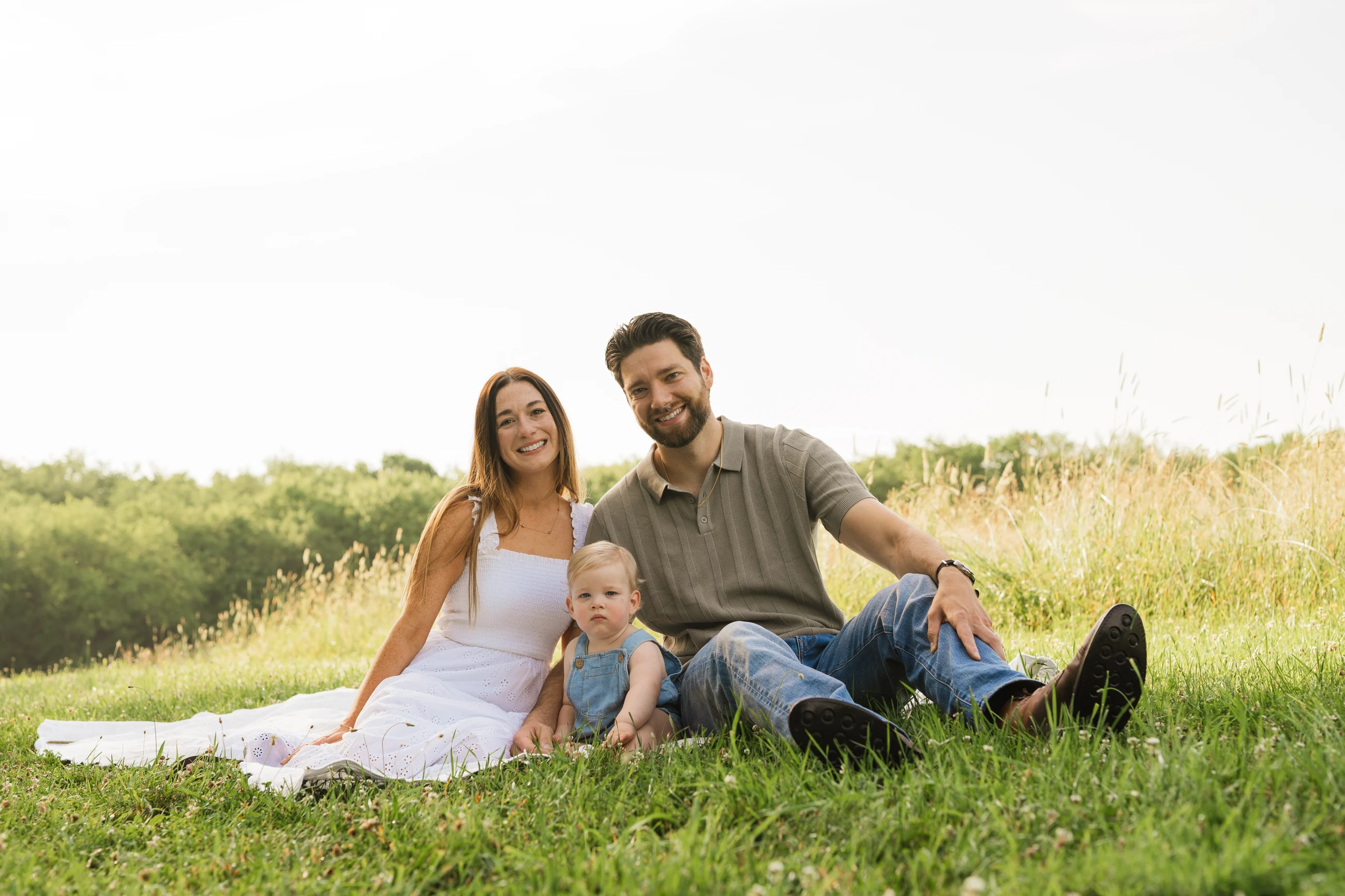Family seated together in a sunlit field