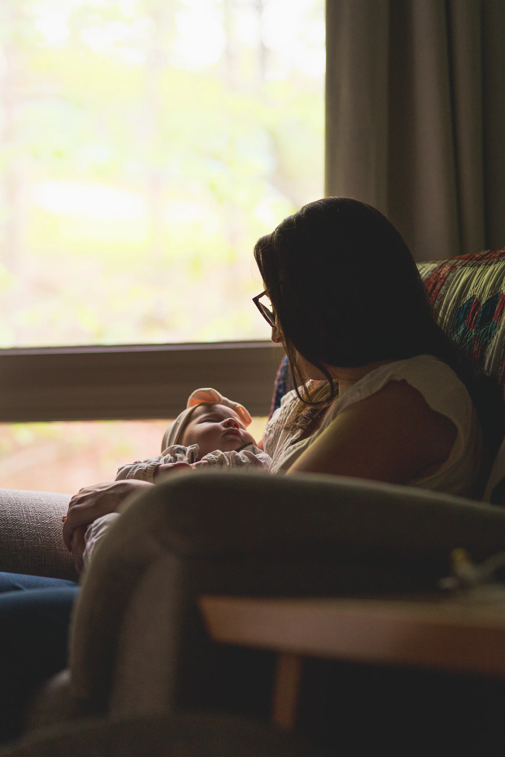 Mother holding her child in quiet window light
