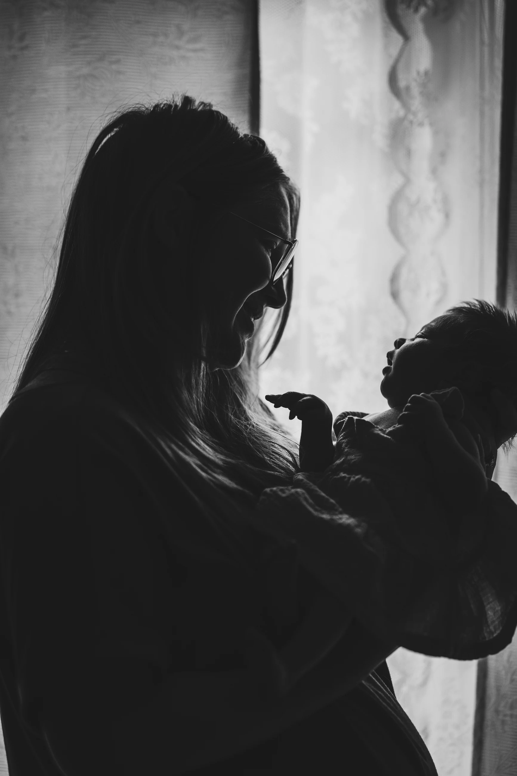Black and white portrait of a parent holding a newborn