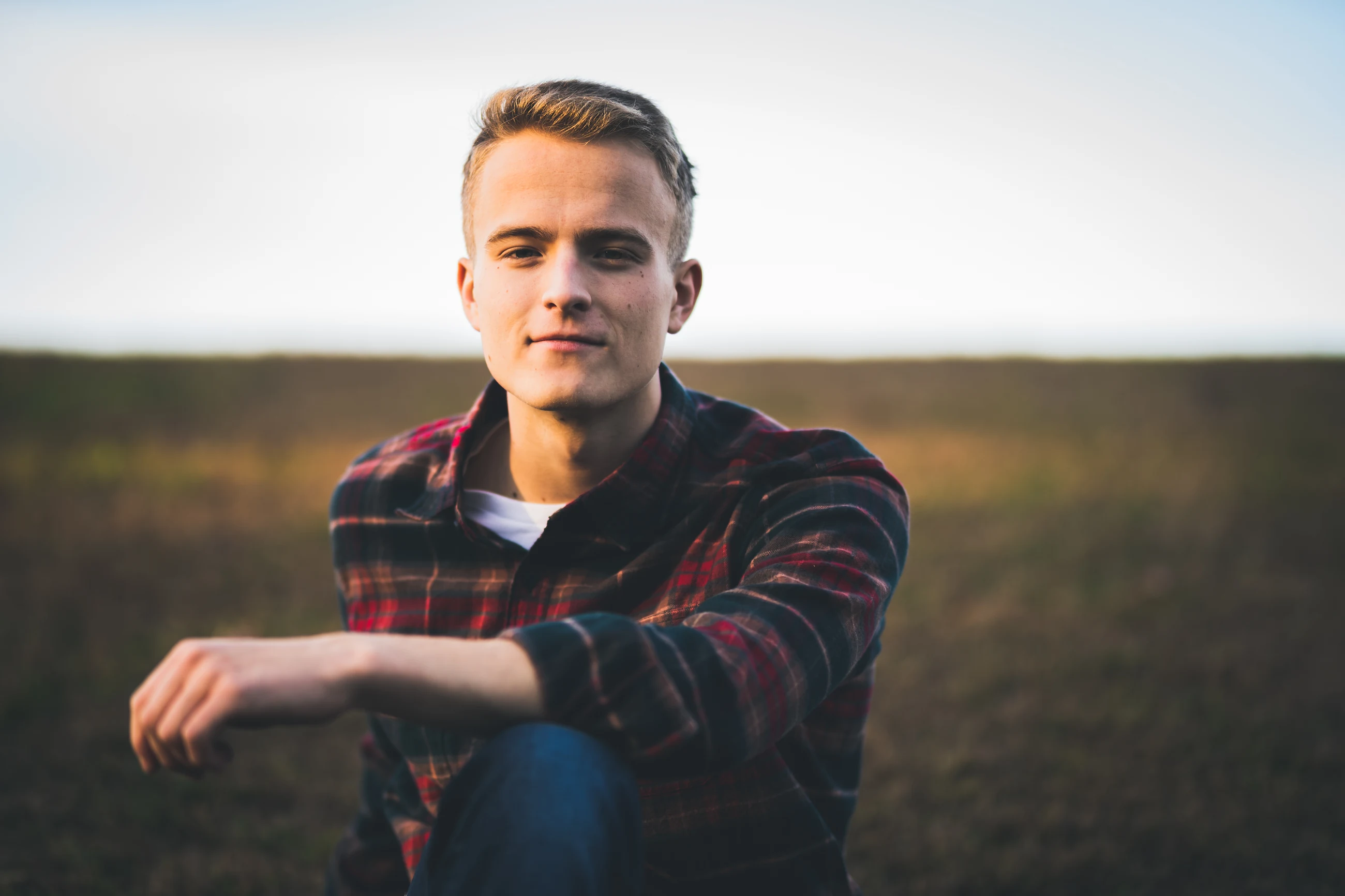 Senior seated in an open field at dusk