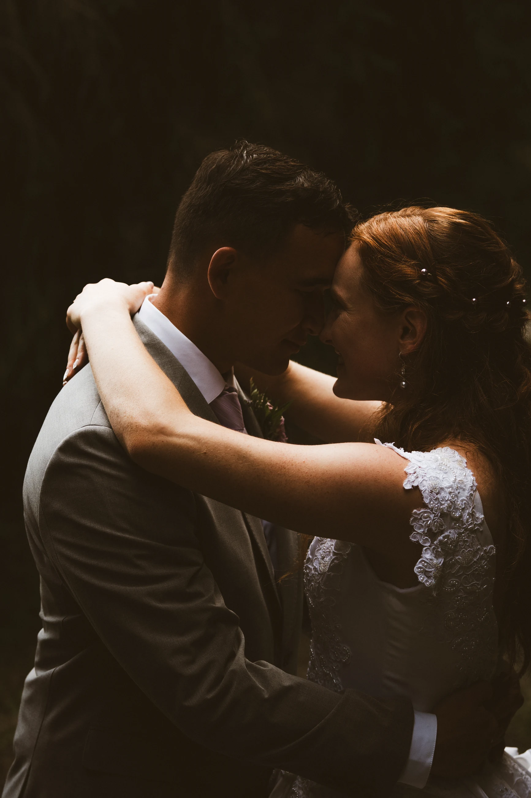 Newlyweds embracing in a shaft of warm light